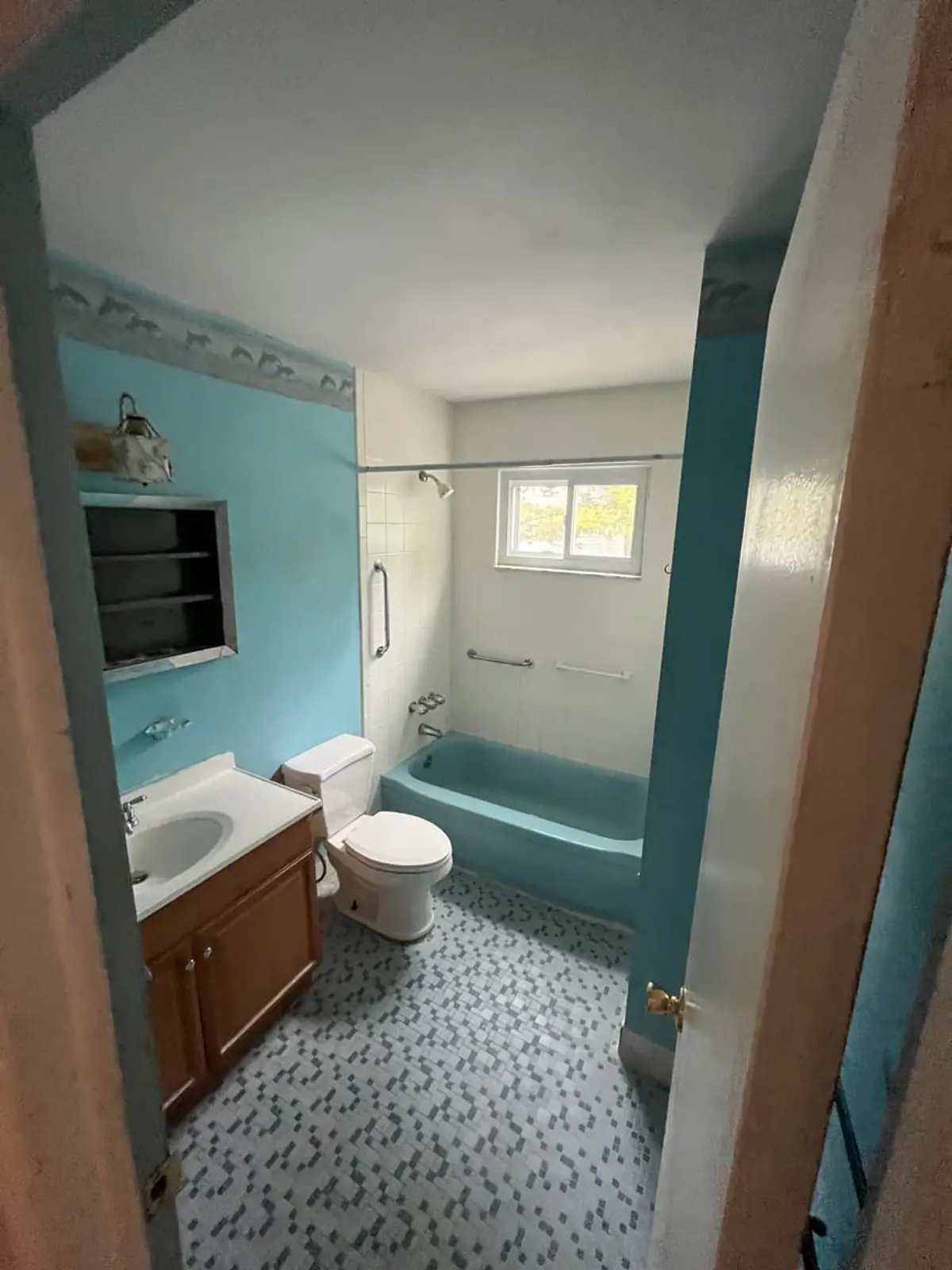 Wondering which Northport neighborhoods we buy in: dated bathroom with a turquoise tub and mosaic floor