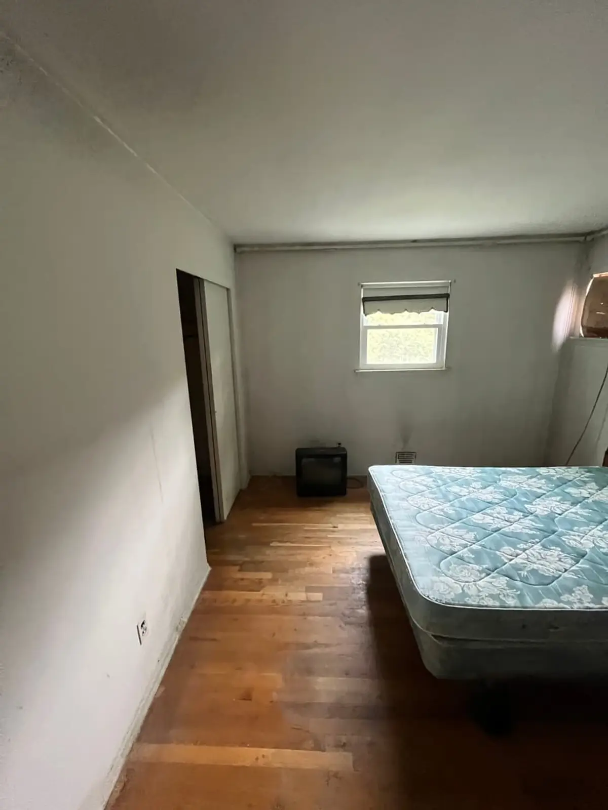 Selling in the Northport housing market: empty bedroom with a bare mattress on hardwood