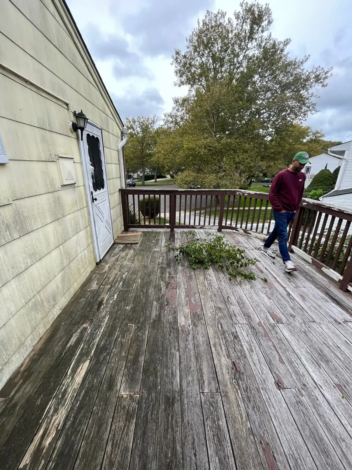 Selling a house near the LIRR in Northport: weathered wood deck with fallen branches on it