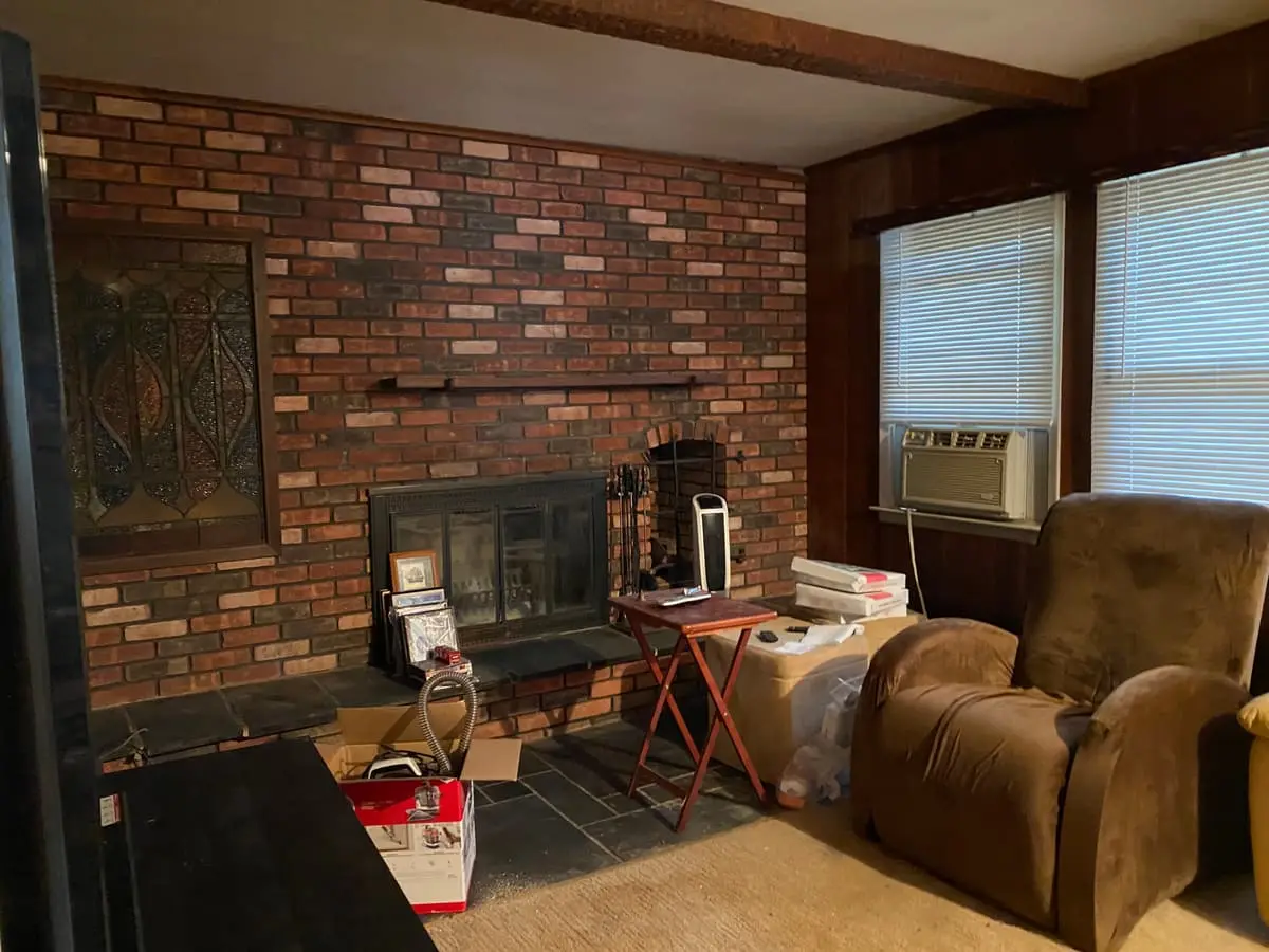 Downsizing or retiring in Northport: wood-paneled den with a brick fireplace wall